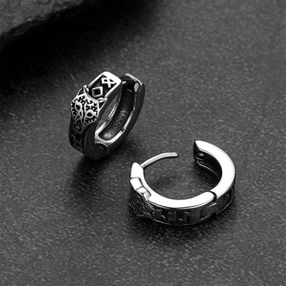 Pair of silver hoop earrings on a dark textured surface