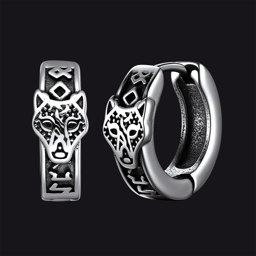 Silver hoop earrings with wolf head design on a black background