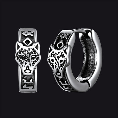 Silver hoop earrings with wolf head design on a black background