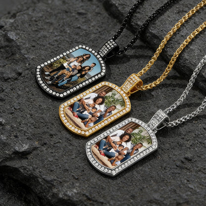 Three photo dog tag pendants on chains against a dark stone background