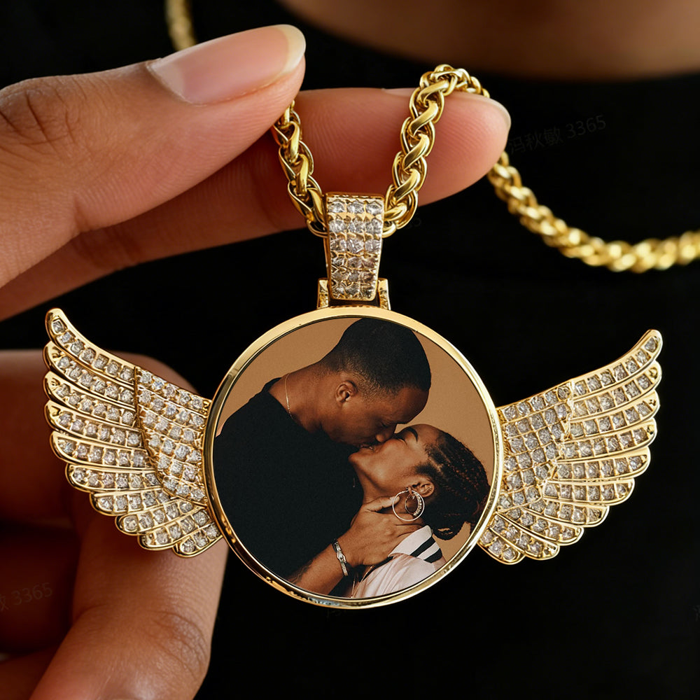 Gold necklace with a pendant featuring a couple's photo, held by a hand against a dark background.