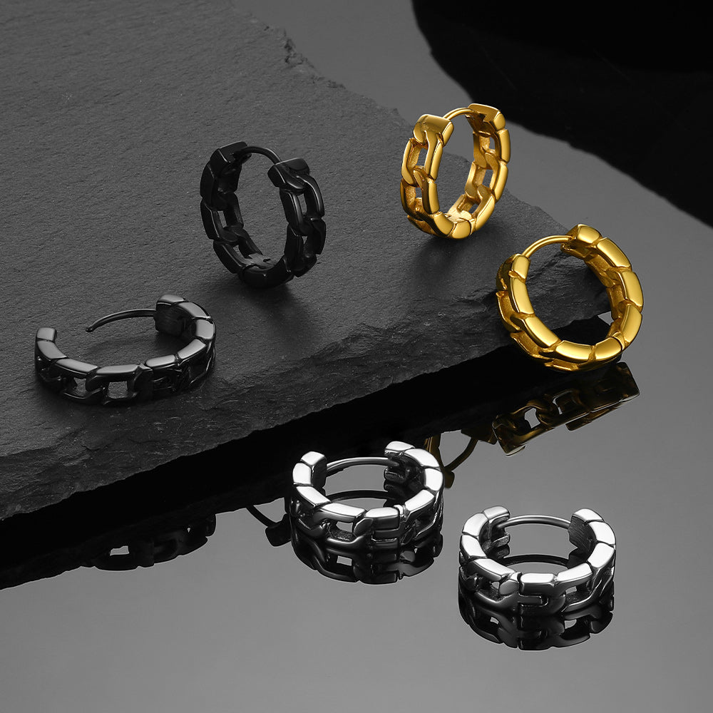 Set of gold, black, and silver hoop earrings on a dark surface.
