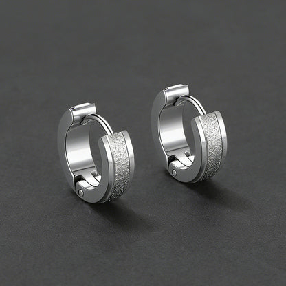 Pair of silver hoop earrings on a dark gray background
