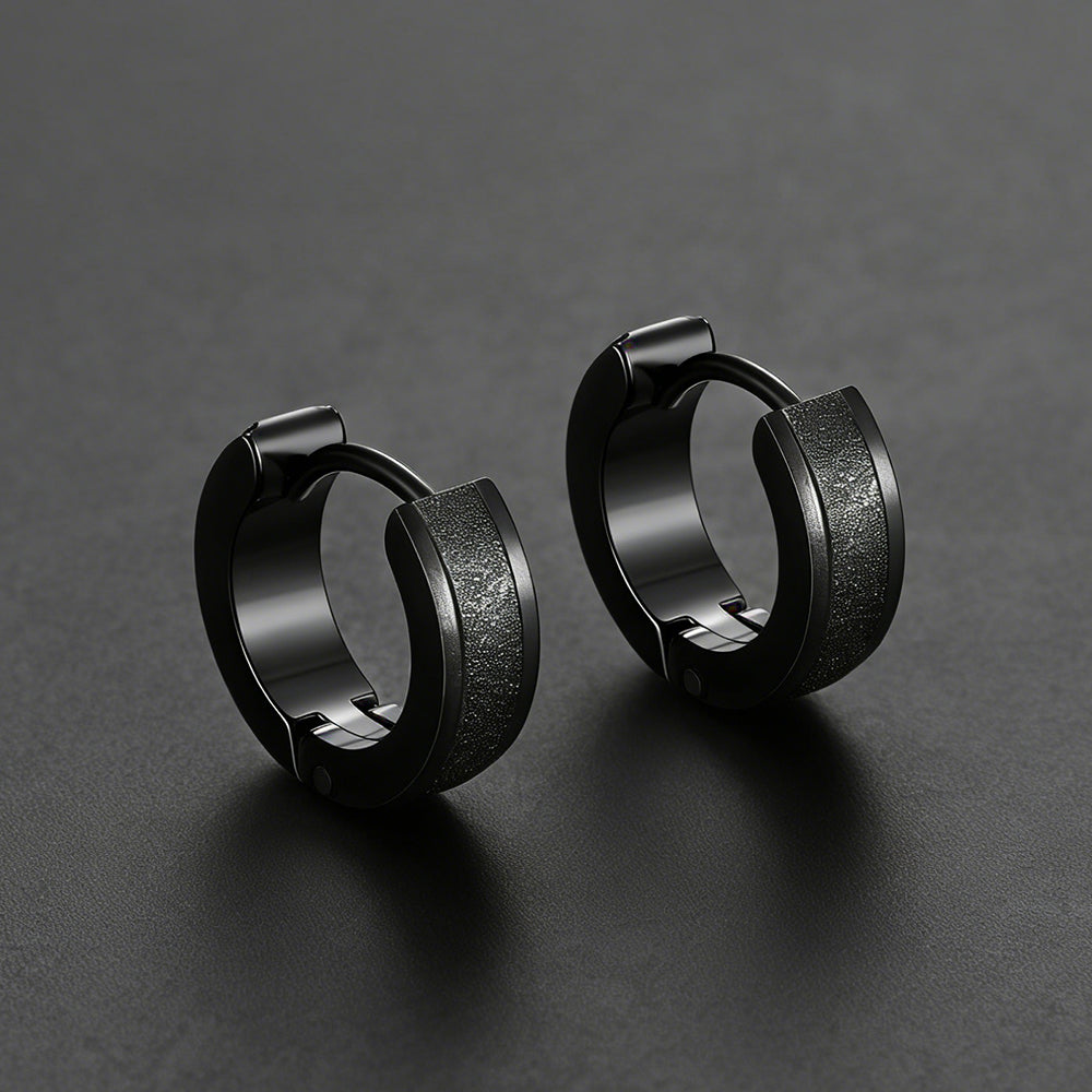 Pair of black hoop earrings on a dark gray background