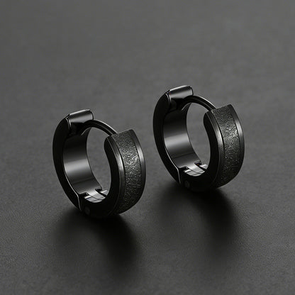 Pair of black hoop earrings on a dark gray background