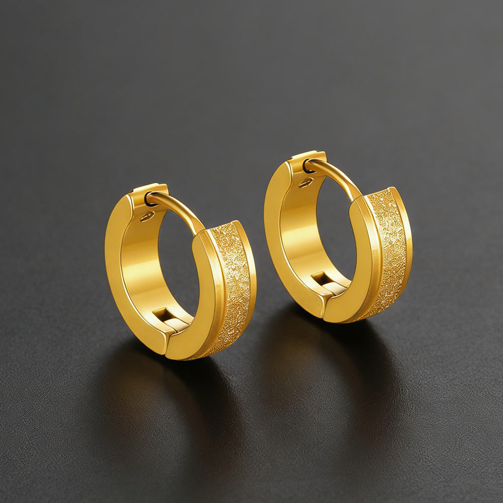Pair of gold hoop earrings on a dark gray background