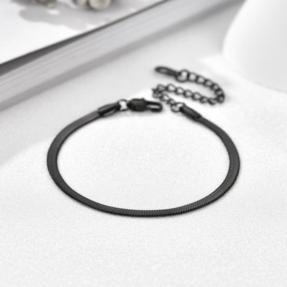Black leather bracelet with metal clasp on a white surface