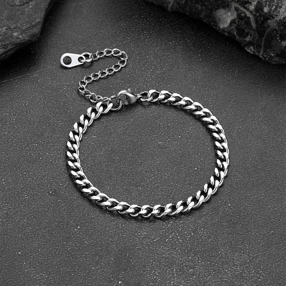 Silver chain bracelet on a dark surface