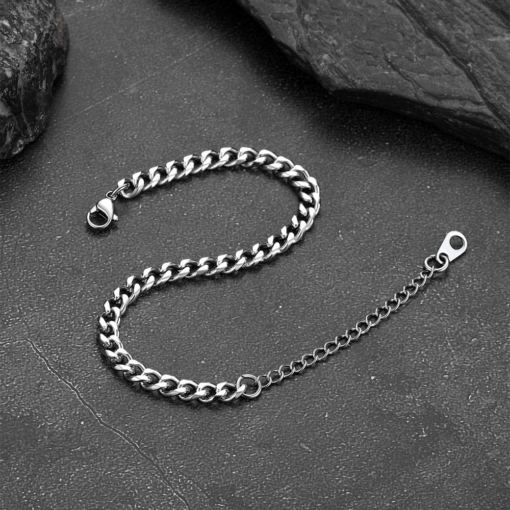 Silver chain bracelet on a dark stone surface