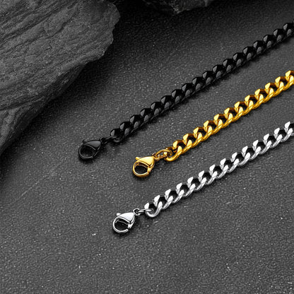 Three chain necklaces in black, gold, and silver on a dark surface.
