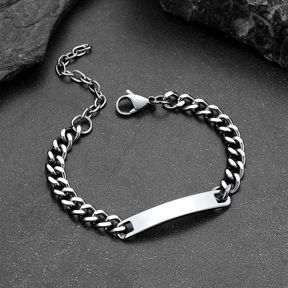 Silver chain bracelet with a nameplate on a dark surface