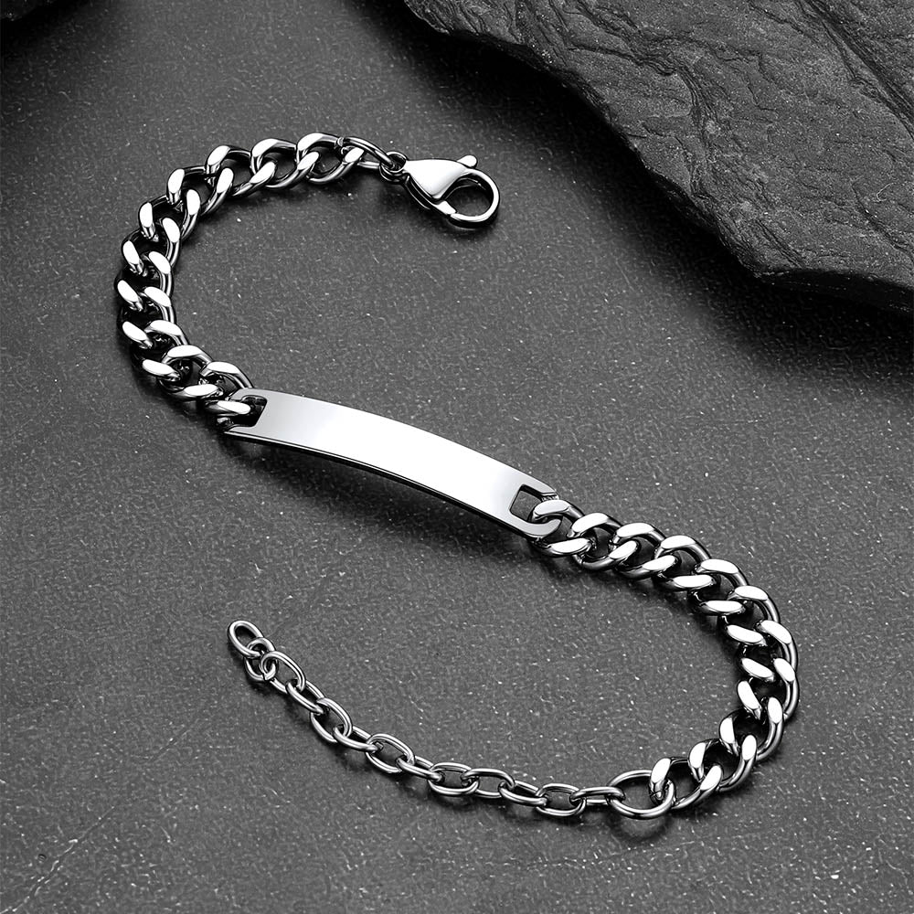 Silver chain bracelet with a bar clasp on a dark stone surface