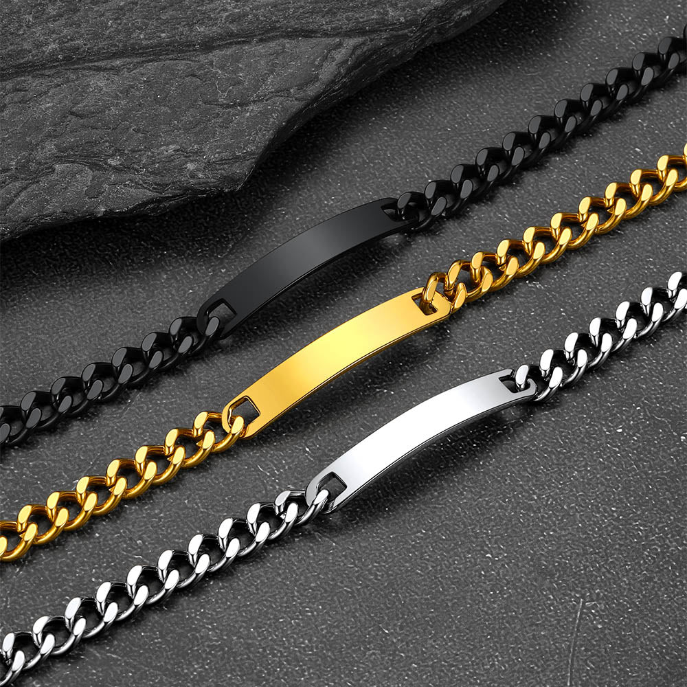 Three chain bracelets in black, gold, and silver on a dark surface.