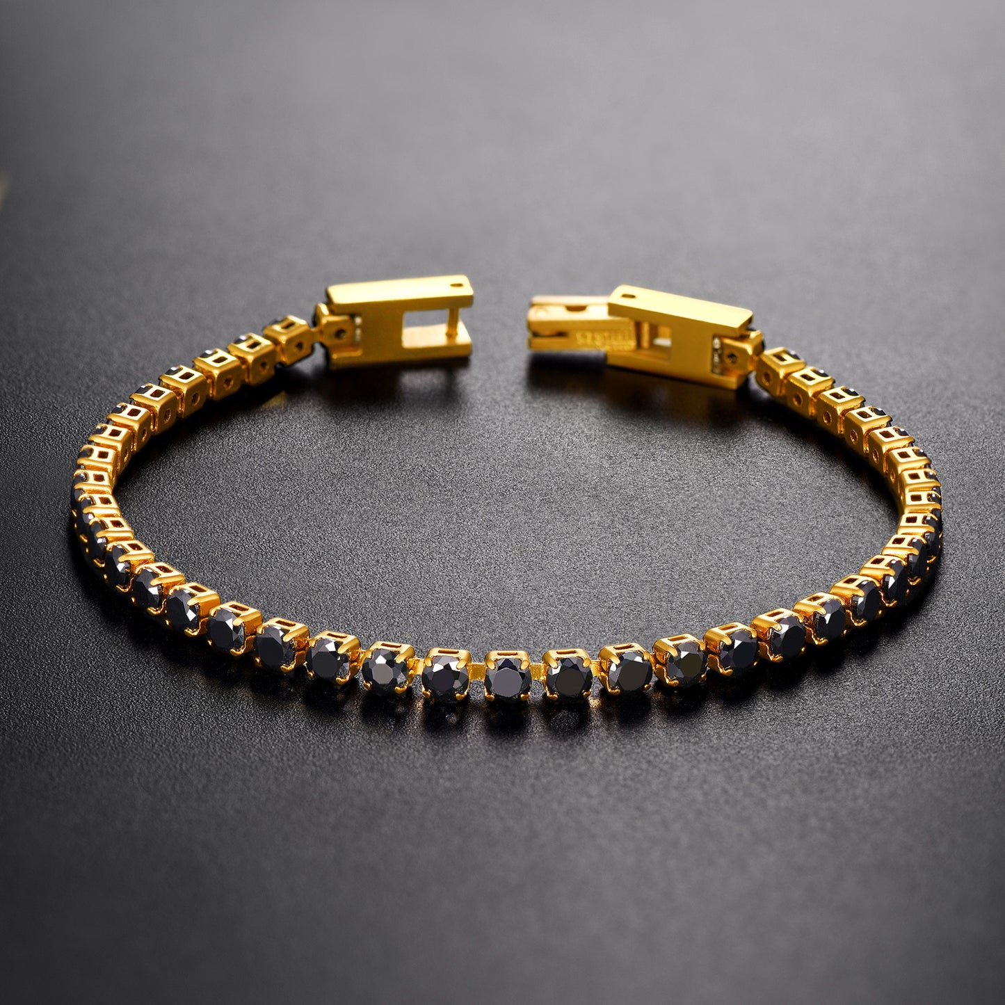 Gold bracelet with black stones on a dark background