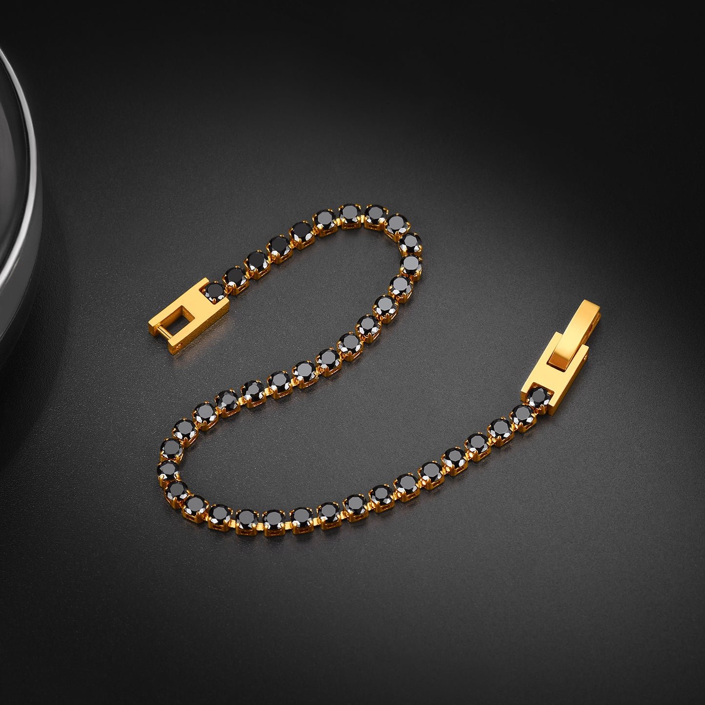Gold bracelet with black stones on a dark background