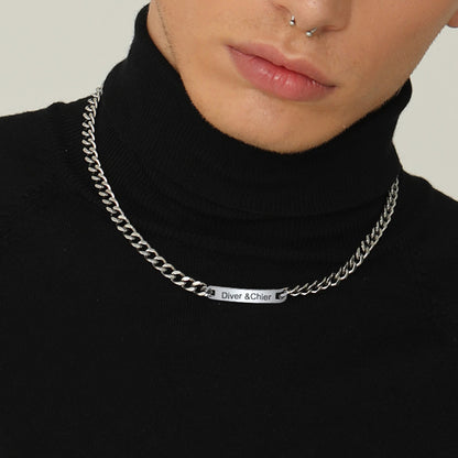 Silver chain necklace with brand name on a black turtleneck