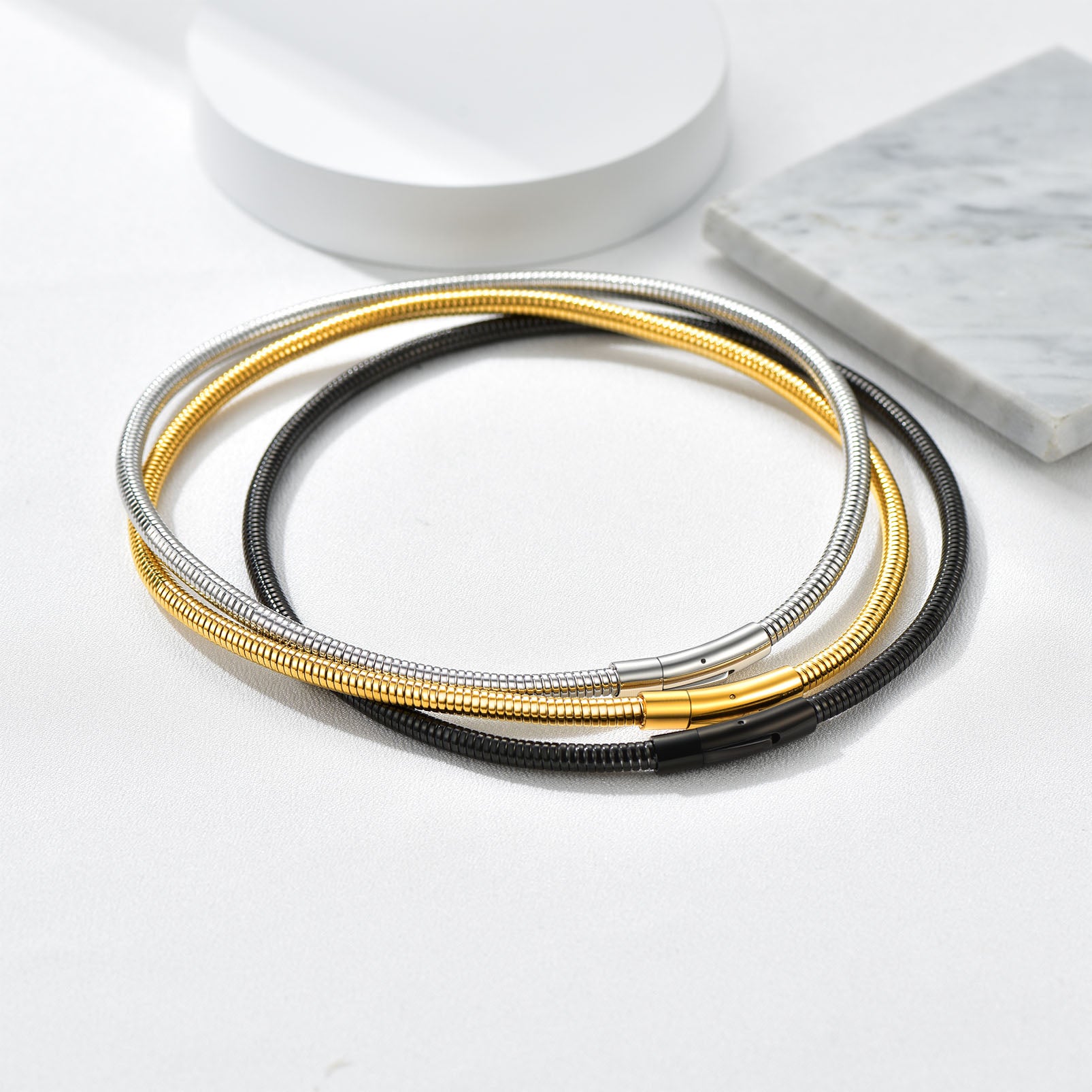 Herringbone snake chain necklaces in gold, black, and silver