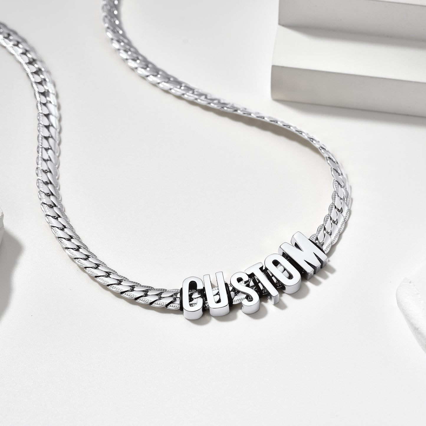 Silver chain necklace with 'CUSTOM' pendant on a white background