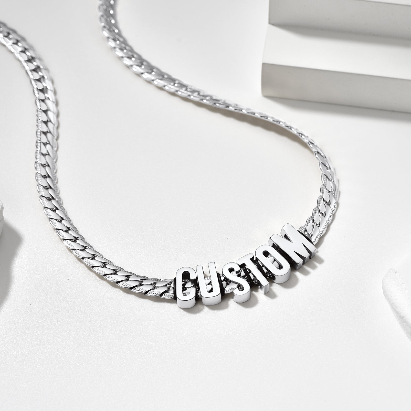 Silver chain necklace with 'CUSTOM' pendant on a white background