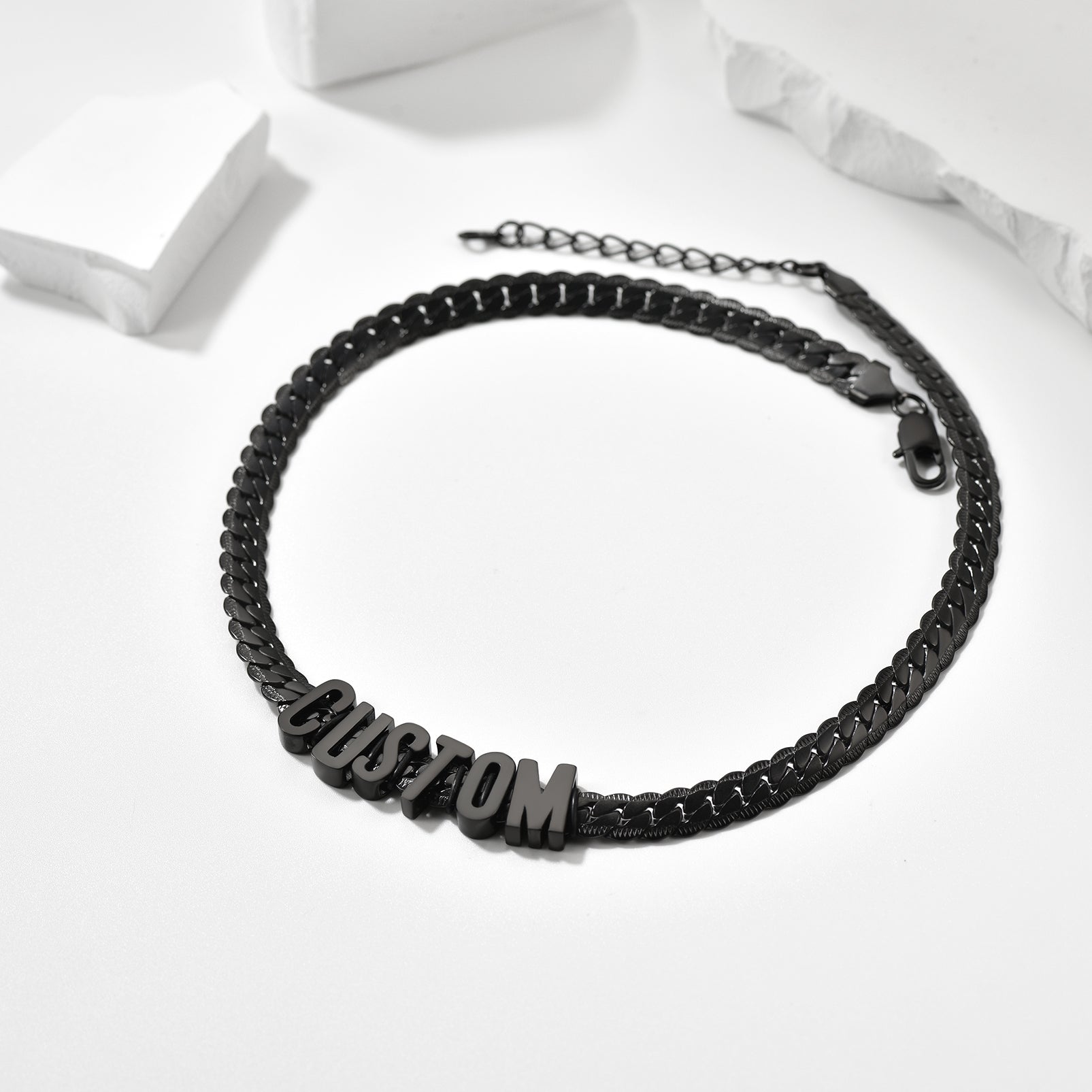 Black braided bracelet with 'CUSTOM' beads on a white background