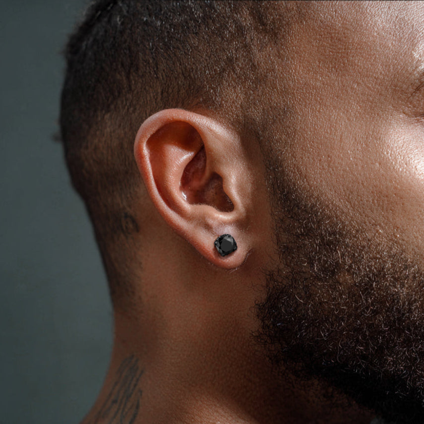 Close-up of a man's ear with a black earring