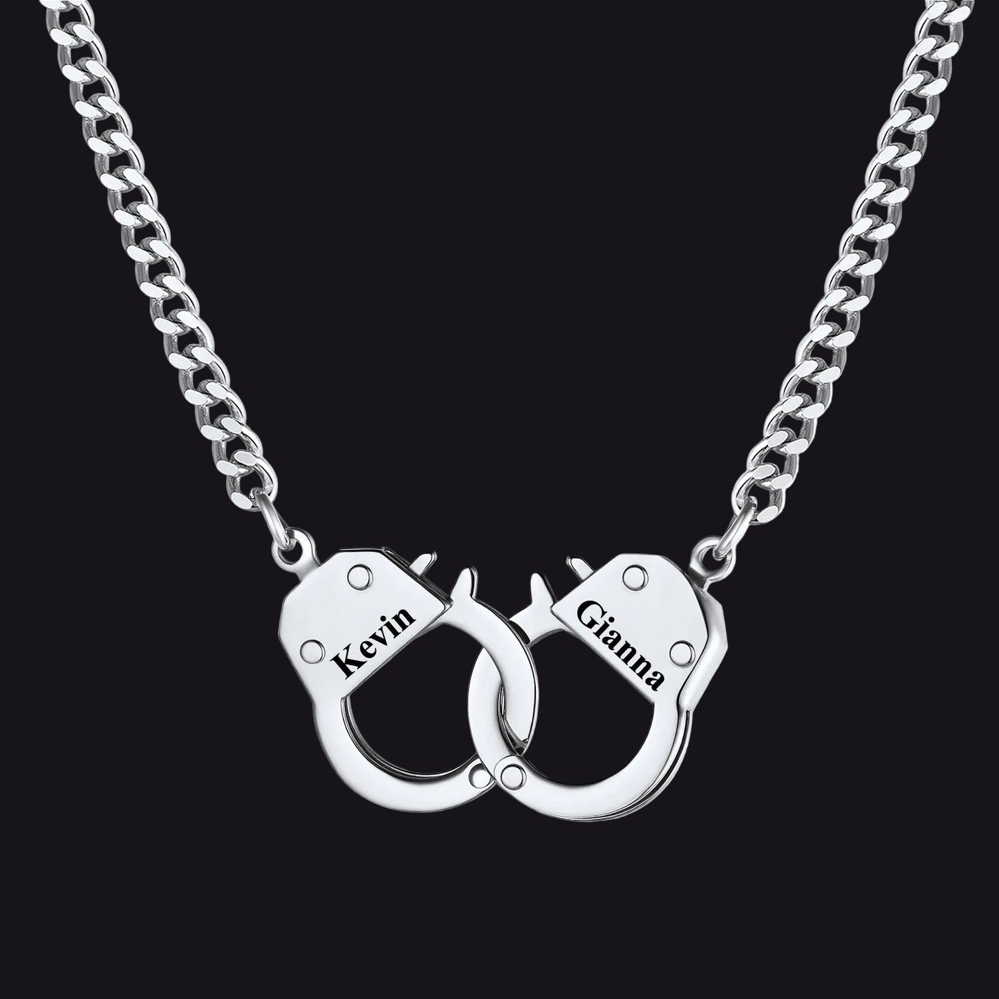 A silver chain necklace with a pendant shaped like two interlocking handcuffs. 