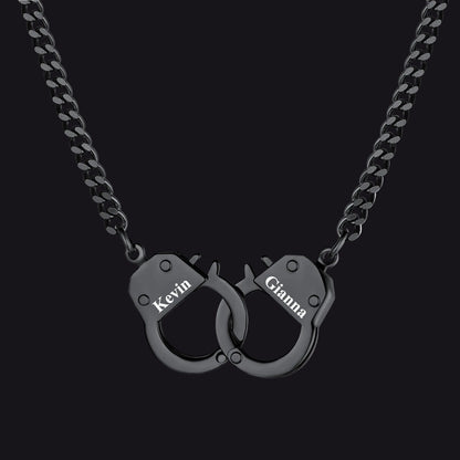 A black metal chain necklace with a pendant shaped like two interlocking handcuffs. 