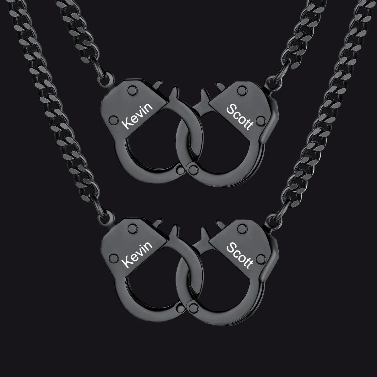 Two matching black metal necklaces with handcuff-shaped pendants.