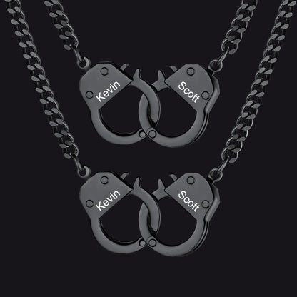 Two matching black metal necklaces with handcuff-shaped pendants.