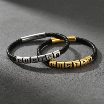 Two braided black cord bracelets with letter beads spelling CUSTOM.