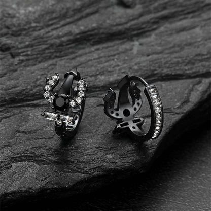 Pair of black Poseidon Trident Greek r hoop earrings on a dark stone surface