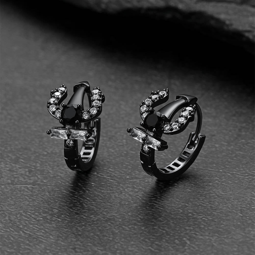 Pair of black Poseidon Trident Greek  hoop earrings on a dark surface