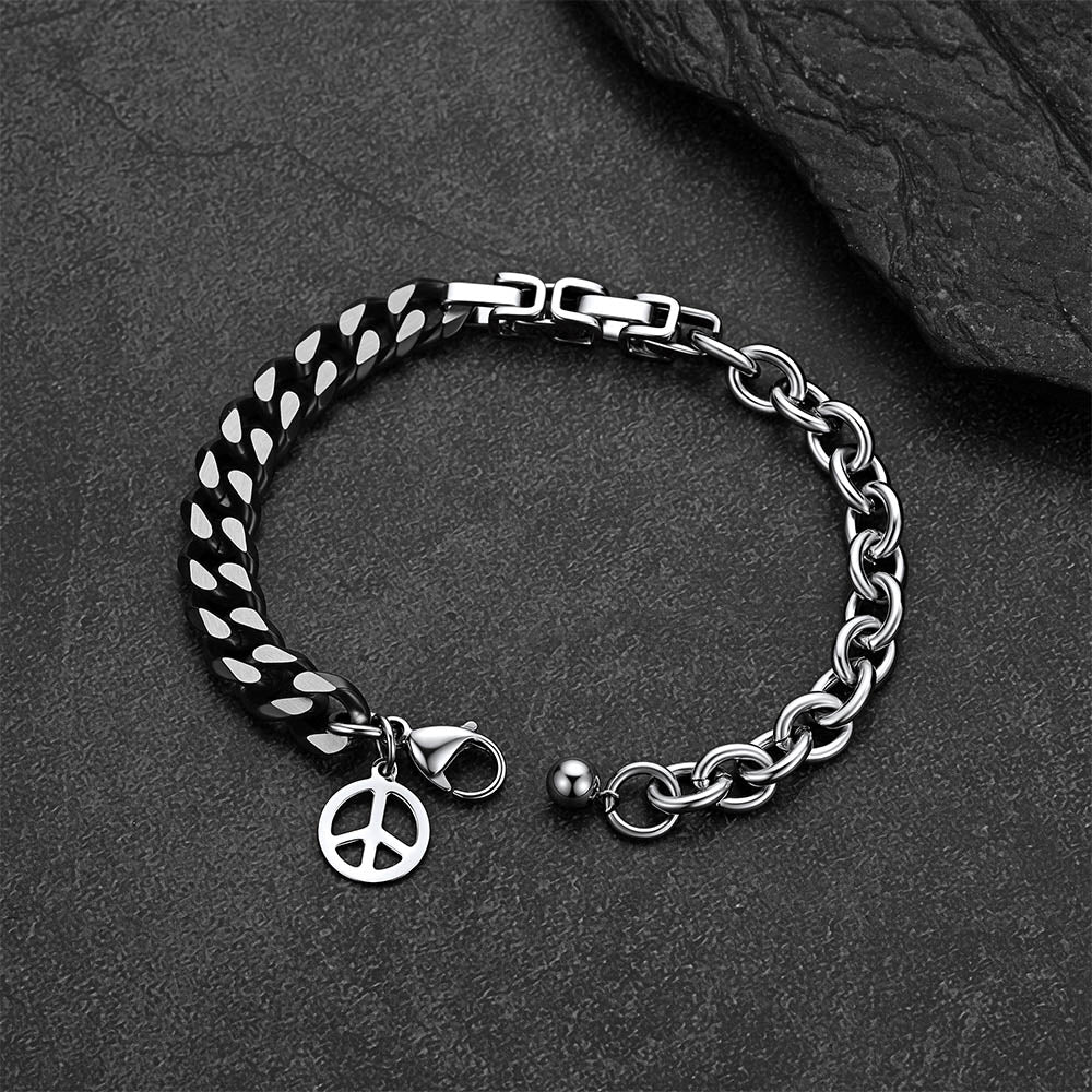 Black and silver Cuban link bracelet against a dark gray rock background.