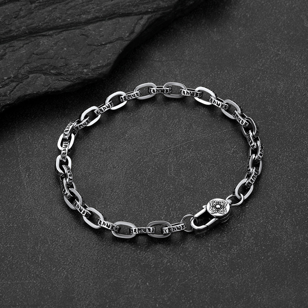 Close-up of engraved paperclip chain bracelet with cyberpunk font lettering