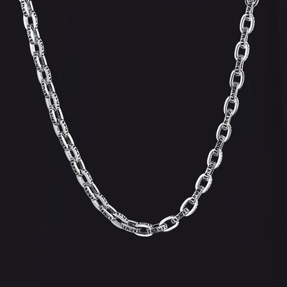A silver-toned metal chain necklace with elongated oval links, shown draped against a solid black background.