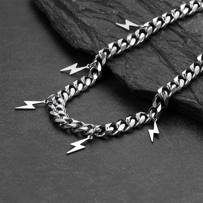 Silver chain with lightning bolt charms on a dark stone surface