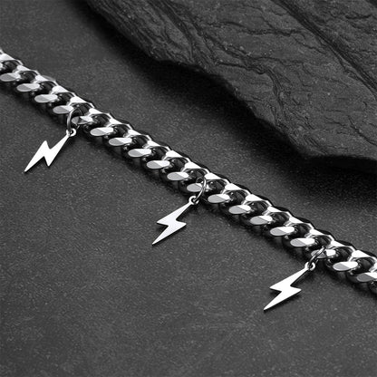 Silver chain with lightning bolt charms on a dark stone surface