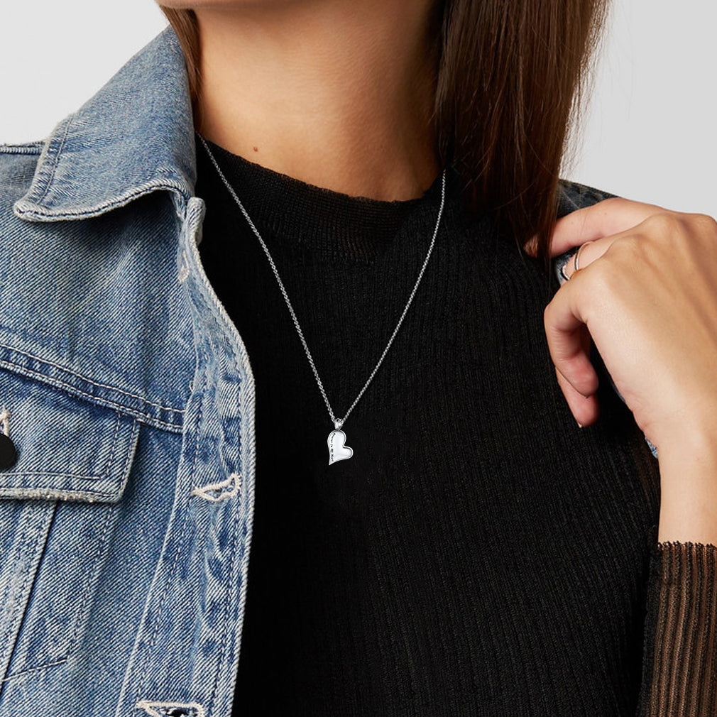 Woman wearing engraved heart urn necklace with delicate chain, remembrance jewelry