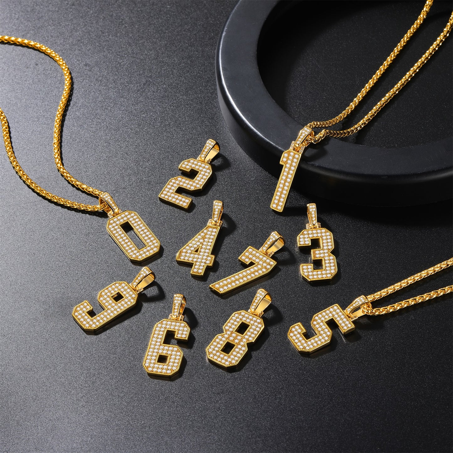 Gold number pendants on a dark surface