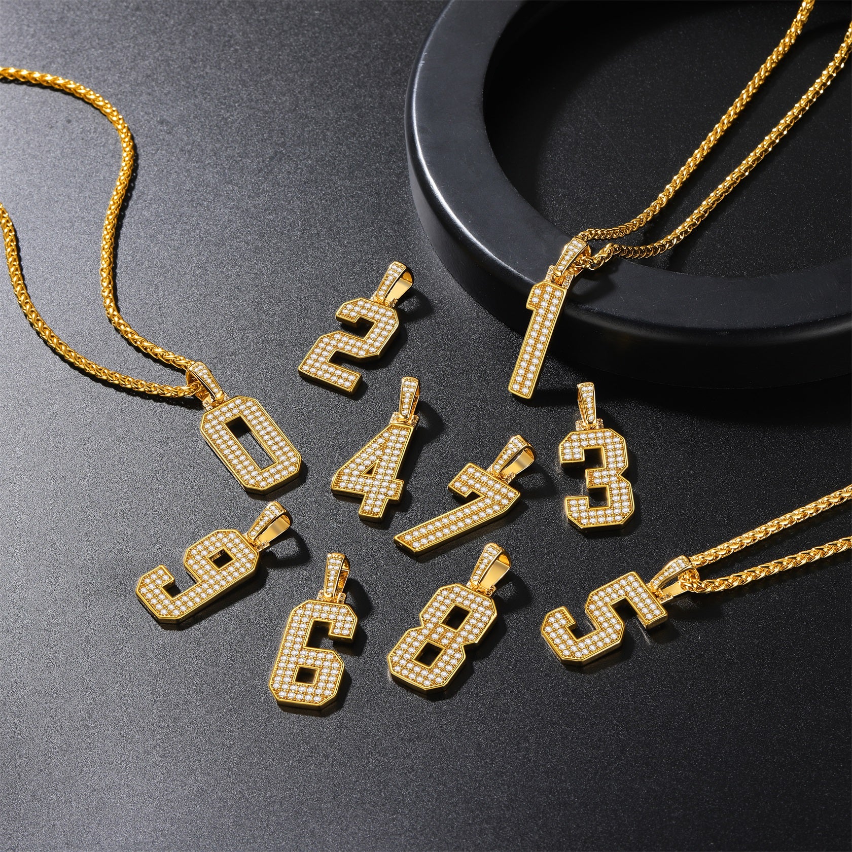 Gold number pendants on a dark surface