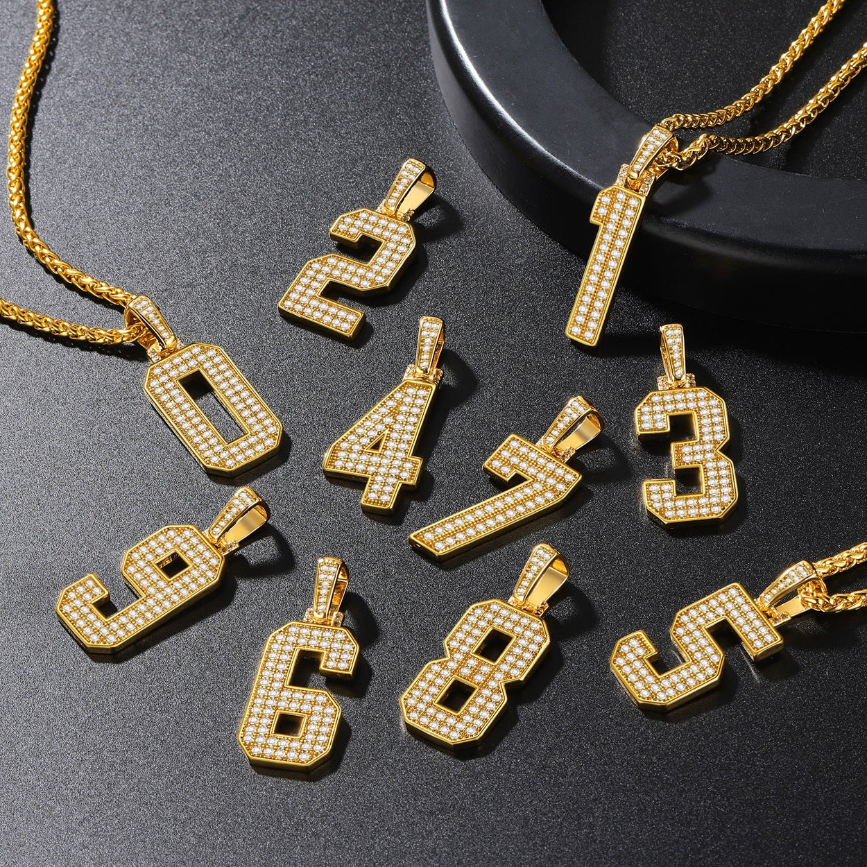 Gold number pendants on a dark surface