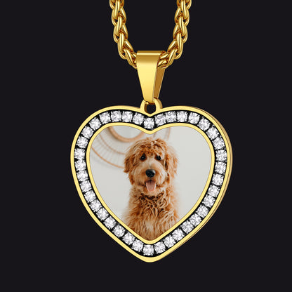 Gold heart-shaped pendant with a photo of a dog inside, on a black background