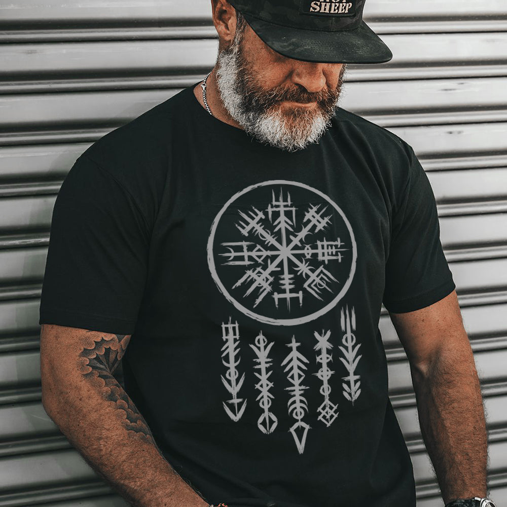 Man wearing a black t-shirt with a white viking symbol design against a metallic background