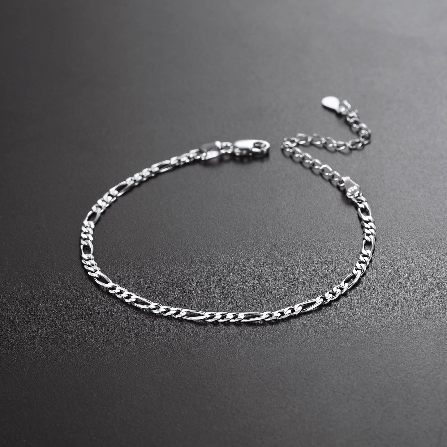 Silver chain bracelet on a dark gray background