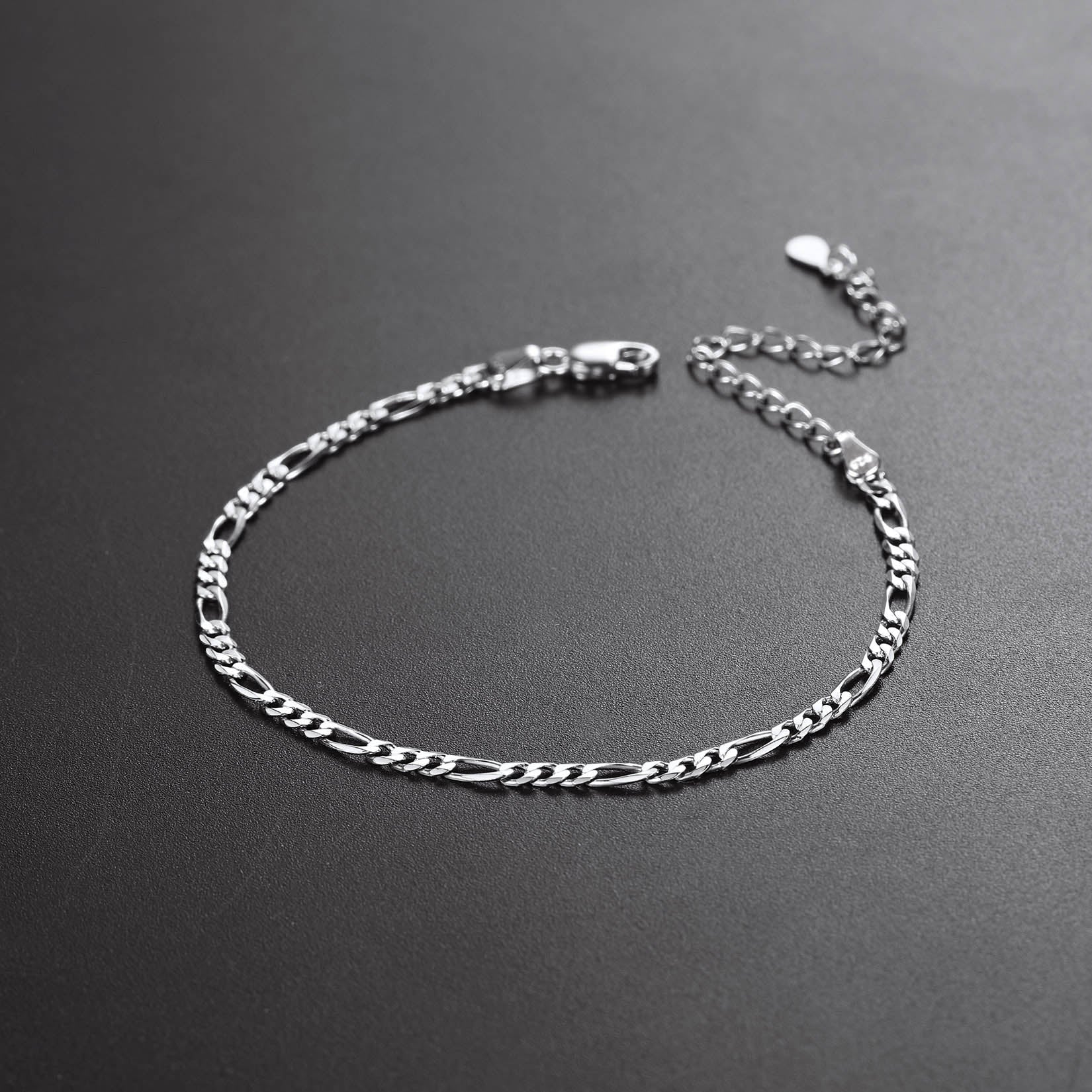 Silver chain bracelet on a dark gray background