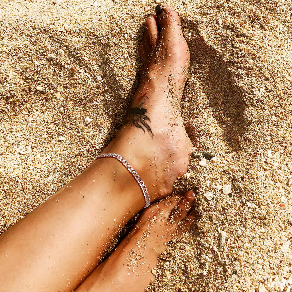 Barefoot model wearing 5mm wide silver Cuban anklet
