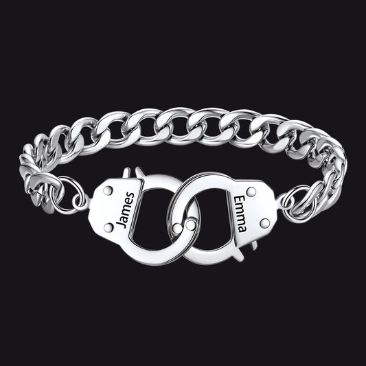 Silver chain bracelet with interlocking handcuffs engraved with names on a black backgroundimg