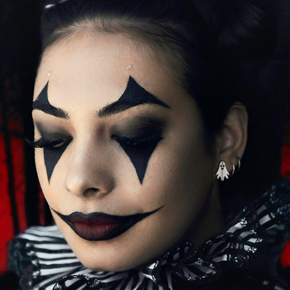 women wearing a ghost earrings and white outfit with dramatic makeup