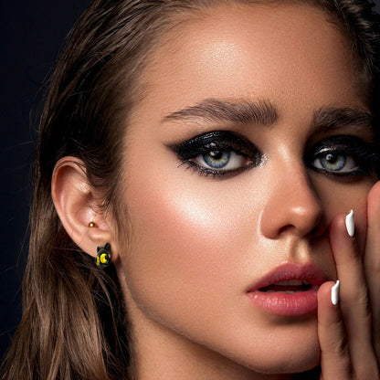 Close-up of a woman with makeup and a dark background