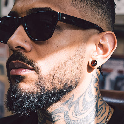 Close-up of a man wearing Nordic Star Rune Fang Stud Earrings